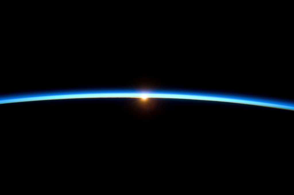 Solen försvinner bakom jordens horisont, det fenomen vi kallar solnedgång, fotograferad från ISS. Bild: NASA